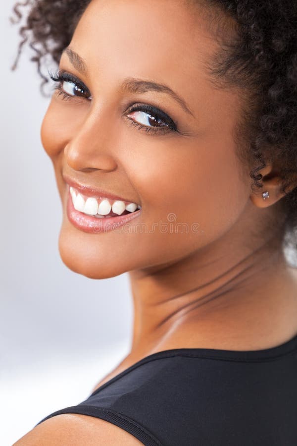 Denti perfetti della donna afroamericana della ragazza della corsa mista fotografie stock libere da diritti Denti perfetti della donna afroamericana della ragazza della corsa mista fotografie stock libere da diritti