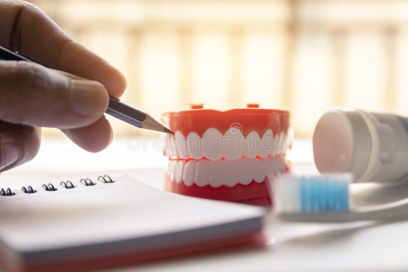 Dentier haut étroit avec la brosse à dents de pâte dentifrice sur le fond brouillé Métaphore pour oral, soins de santé toothy de image stock Dentier haut étroit avec la brosse à dents de pâte dentifrice sur le fond brouillé Métaphore pour oral, soins de santé toothy de image stock