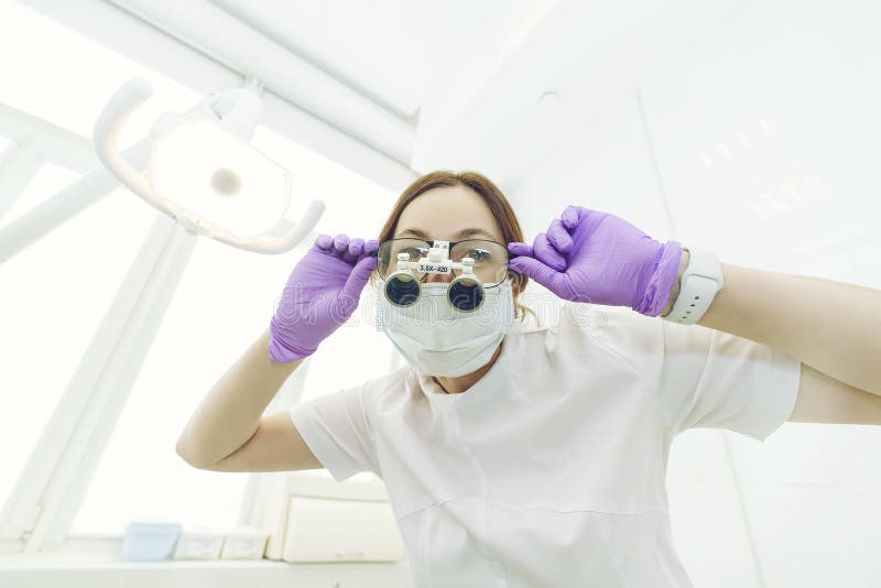 Dentist Bends Over the Patient and is about To Begin the Examination