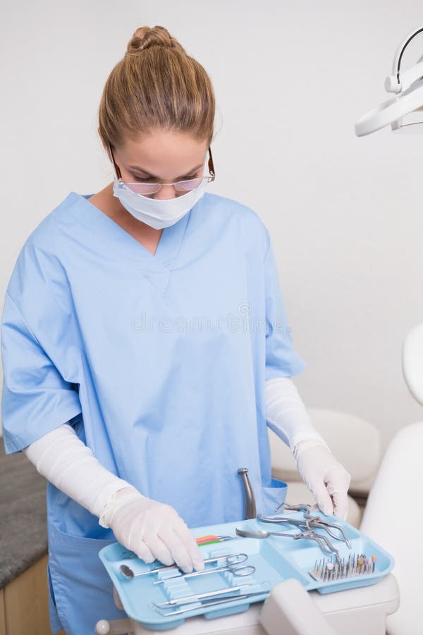 Dentist in Blue Scrubs Looking at Her Tools Stock Photo Image of