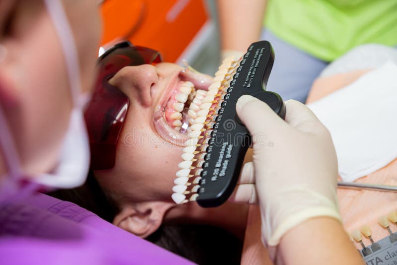 Dentist curing female patient Woman teeth examined at dentists teeth whitening. stomatology office Teeth care and tooth health. selective focus, series