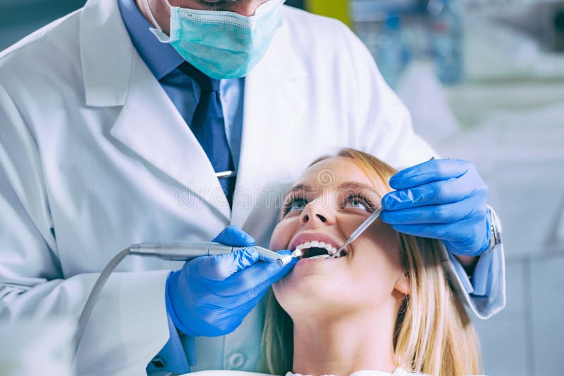 Dentist Drilling Woman Teeth during Oral Dental Procedure Stock Photo