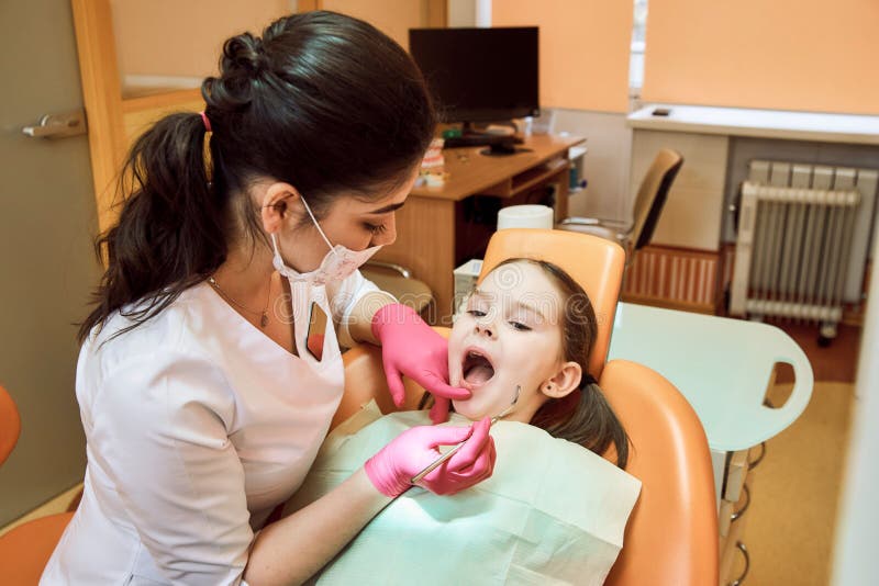 Pediatric dentistry. Dentist treats teeth of little girl royalty free stock photo Pediatric dentistry. Dentist treats teeth of little girl royalty free stock photo