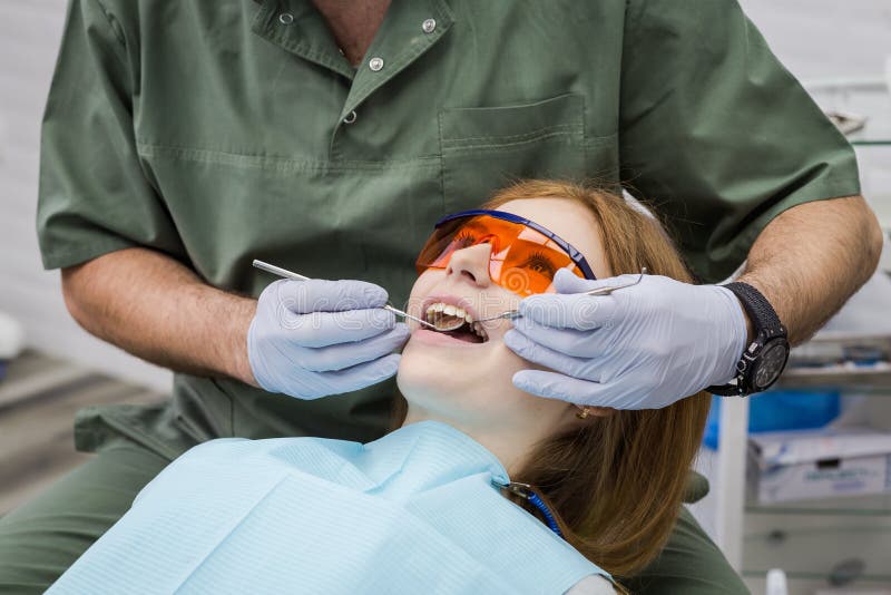 Dentist Examining Girl`s Teeth in Clinic. Dental Problem. Stock Photo