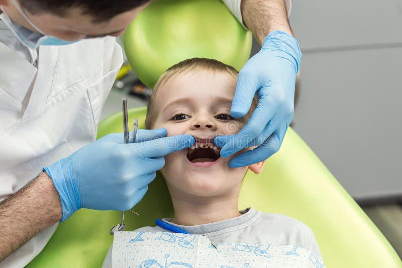 Dentist Examining Little Boy`s Teeth in Clinic. Dental Problem. Stock