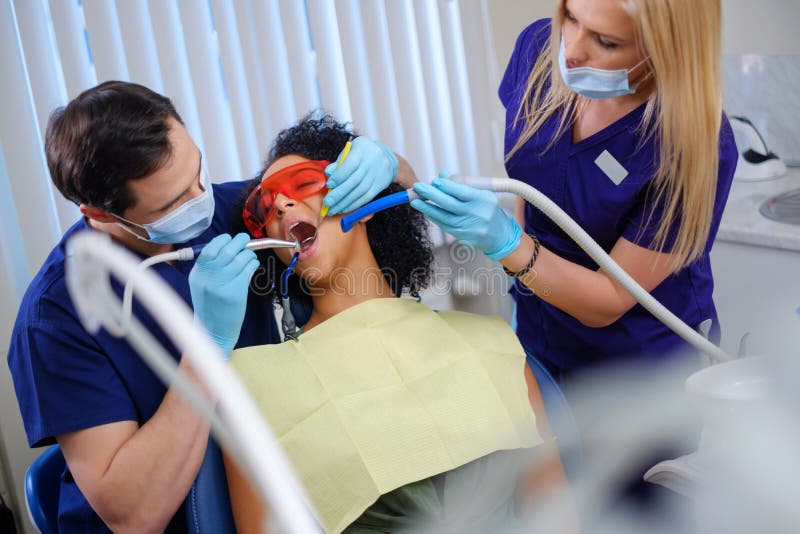 Dentist and his assitant working in private practice stock image Dentist and his assitant working in private practice stock image
