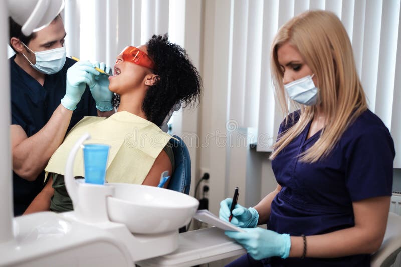 Dentist and His Assitant Working in Private Practice Stock Photo