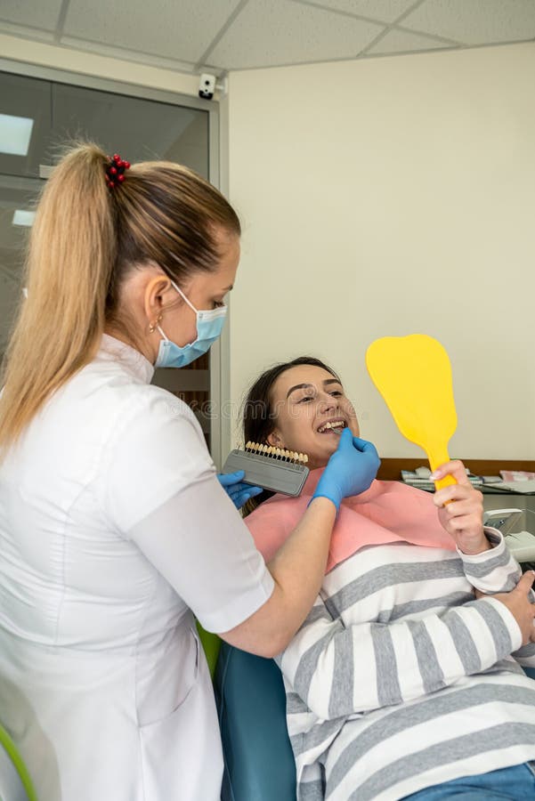 Dentist Hold Samples for Bleaching Treatment Choosing Shade To Her