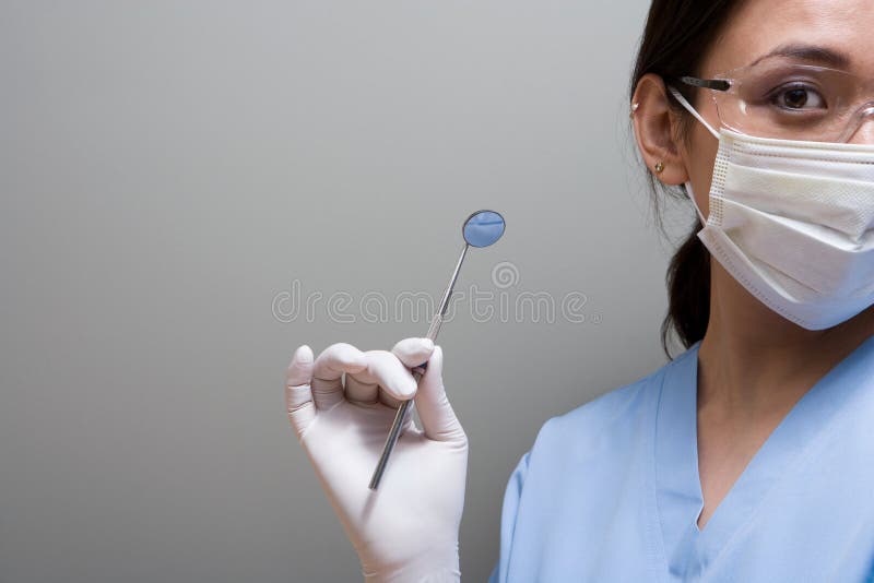 Dentist holding a piece of dental equipment royalty free stock photography