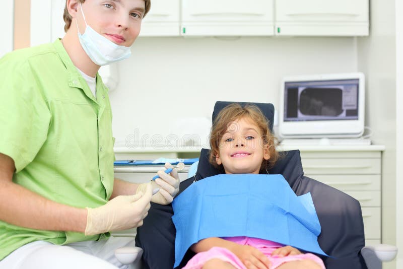 Dentist holds instruments and girl lies in chair royalty free stock photo Dentist holds instruments and girl lies in chair royalty free stock photo