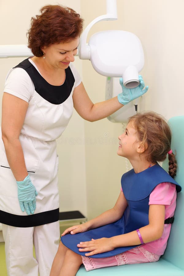 Dentist prepares girl to jaw x-ray image royalty free stock photos