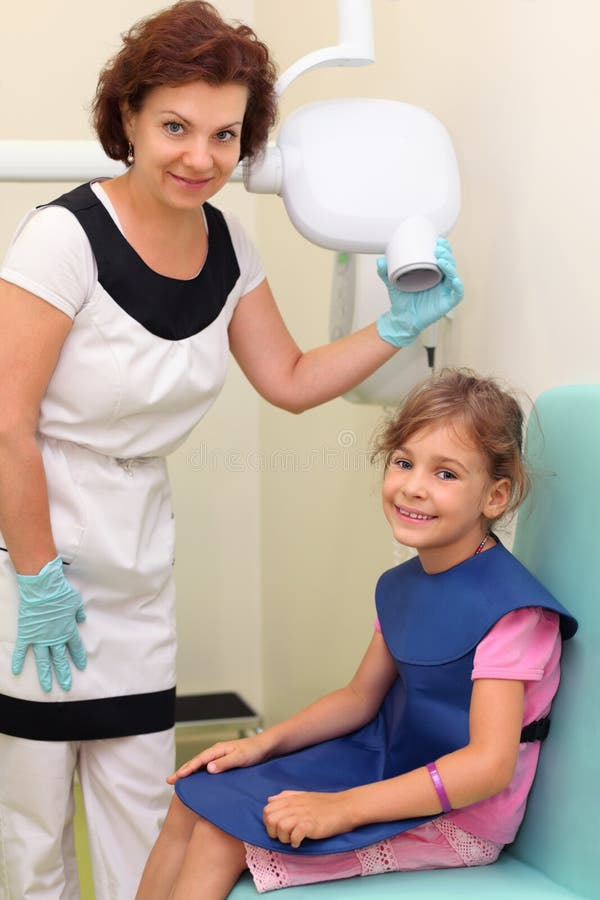 Dentist prepares girl to jaw x-ray image royalty free stock images