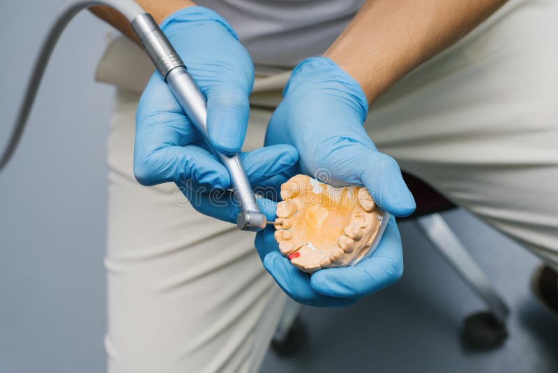Dentist Shows How To Drill a Tooth with a Drill on a Plaster Model of a