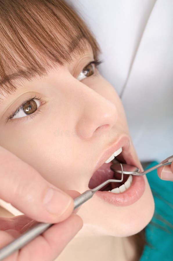 A dentist is treating teeth of young girl stock images A dentist is treating teeth of young girl stock images