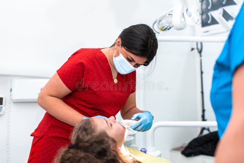 The Dentist Uses an Ultraviolet Lamp while Fitting the Girl with Braces