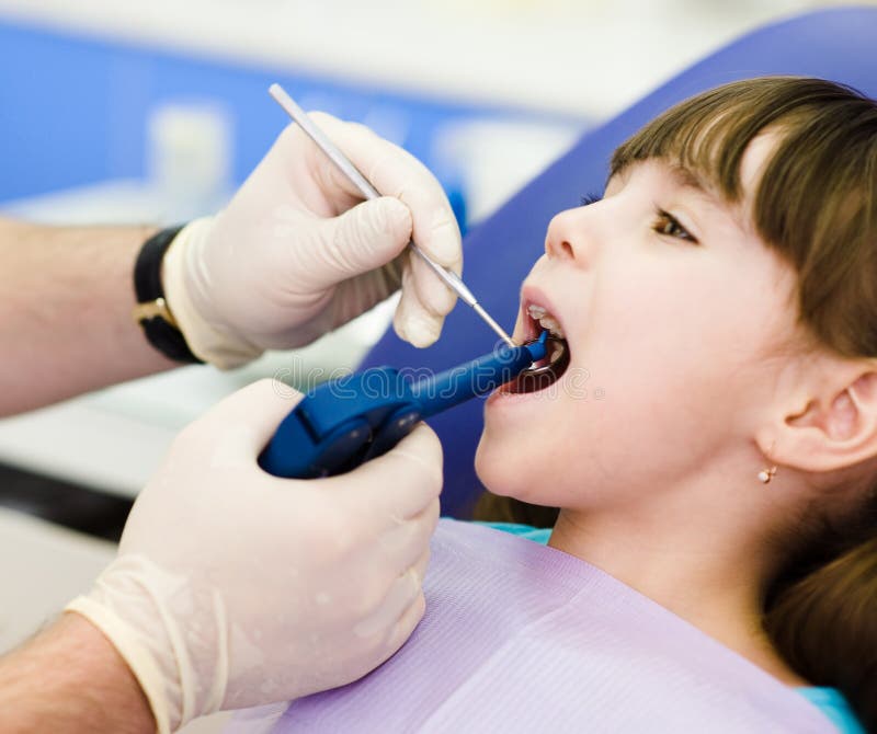 Dentist using dental filling gun on kid stock photos Dentist using dental filling gun on kid stock photos