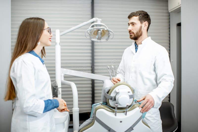 Dentist with Woman Assistant in the Dental Office Stock Photo Image