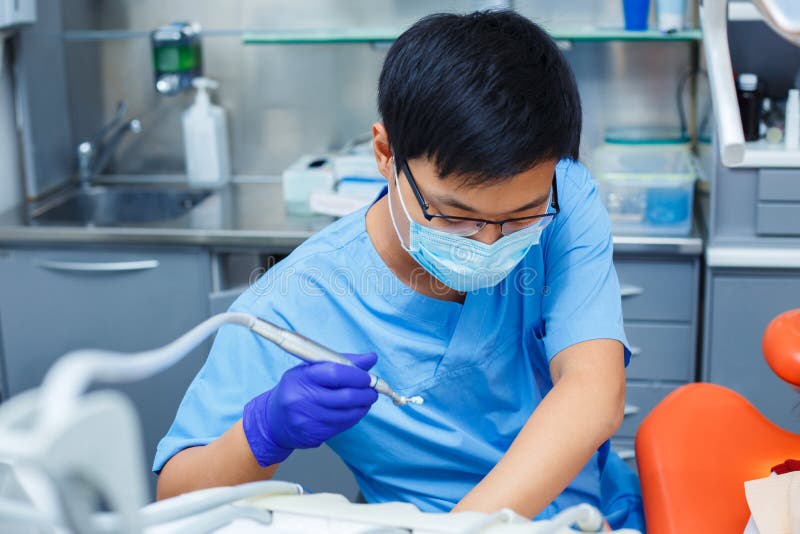 Dentist at work. Close up of young Asian doctor in medical mask. stock photo Dentist at work. Close up of young Asian doctor in medical mask. stock photo