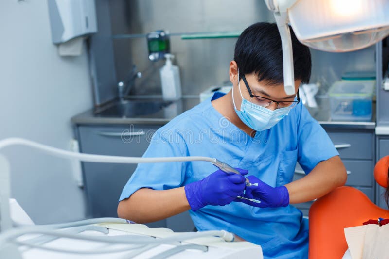 Dentist at work. Close up of young Asian doctor in medical mask stock photography Dentist at work. Close up of young Asian doctor in medical mask stock photography