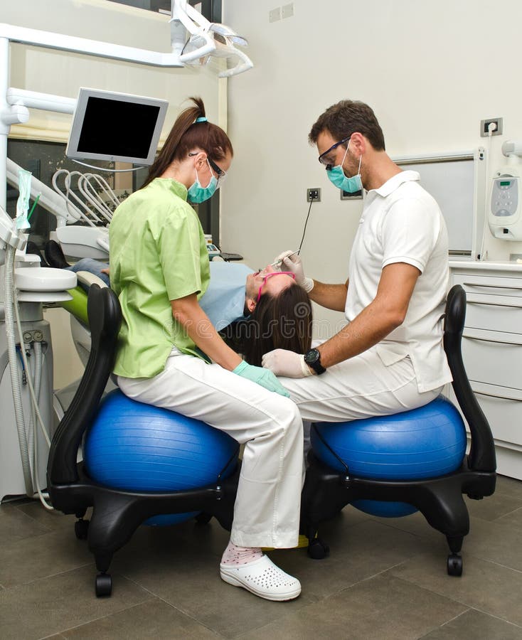 Dentista, ayudante y paciente en clínica dental imagenes de archivo Dentista, ayudante y paciente en clínica dental imagenes de archivo