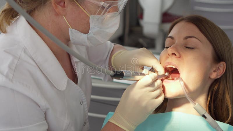 Dentista che tratta i denti al paziente della donna in clinica Medico professionista femminile sul lavoro Controllo dentale