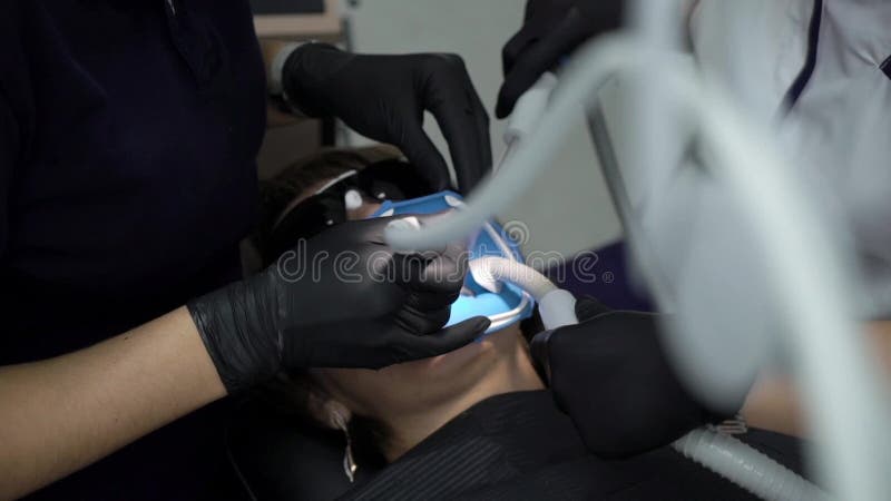 Dentista che tratta i denti al paziente della donna in clinica Stomatologo professionale femminile di medico sul lavoro Assegno d