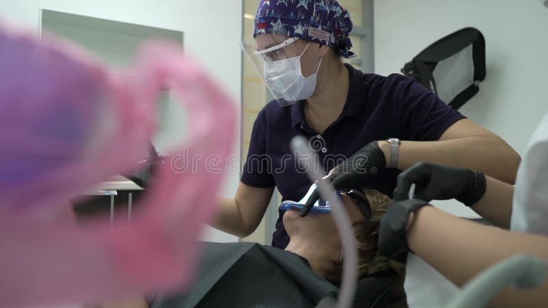 Dentista che tratta i denti al paziente della donna in clinica Stomatologo professionale femminile di medico sul lavoro Assegno d