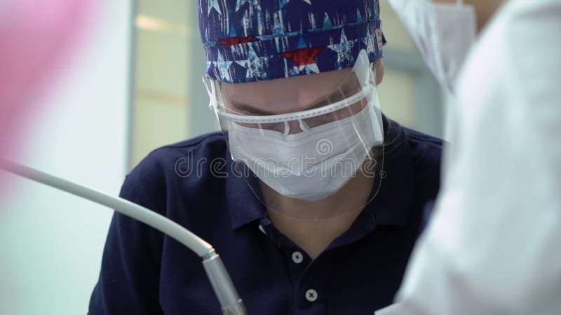 Dentista che tratta i denti al paziente della donna in clinica Stomatologo professionale femminile di medico sul lavoro Assegno d