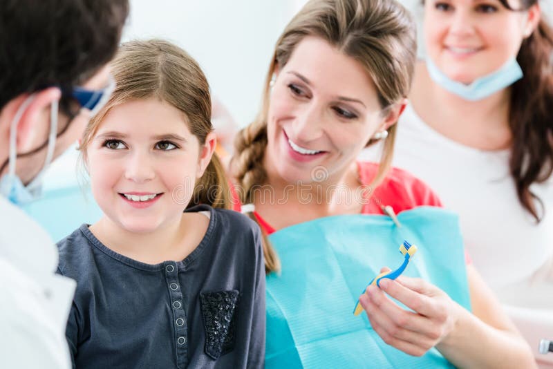 Dentista con la mujer embarazada y el niño en cirugía fotografía de archivo libre de regalías Dentista con la mujer embarazada y el niño en cirugía fotografía de archivo libre de regalías