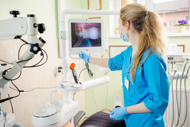 Dentista della donna che esamina l'immagine in tensione dei denti fotografie stock libere da diritti Dentista della donna che esamina l'immagine in tensione dei denti fotografie stock libere da diritti