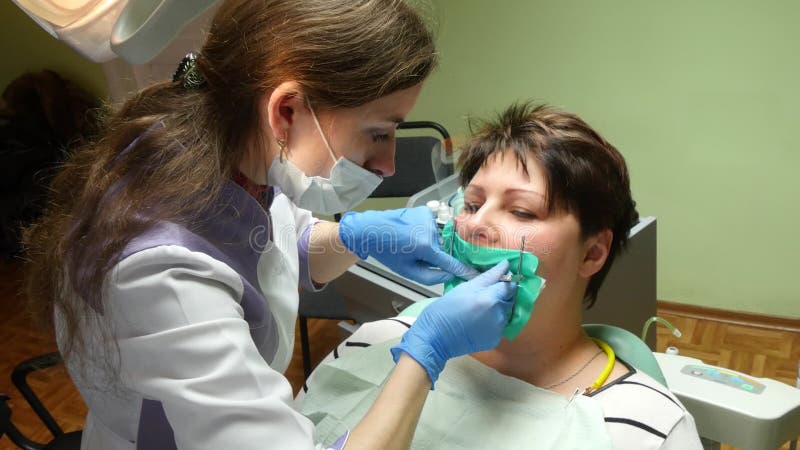 Dentista della donna che lavora ai suoi denti dei pazienti
