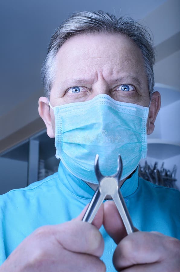 Dentista enojado con los alicates en sus manos imágenes de archivo libres de regalías Dentista enojado con los alicates en sus manos imágenes de archivo libres de regalías