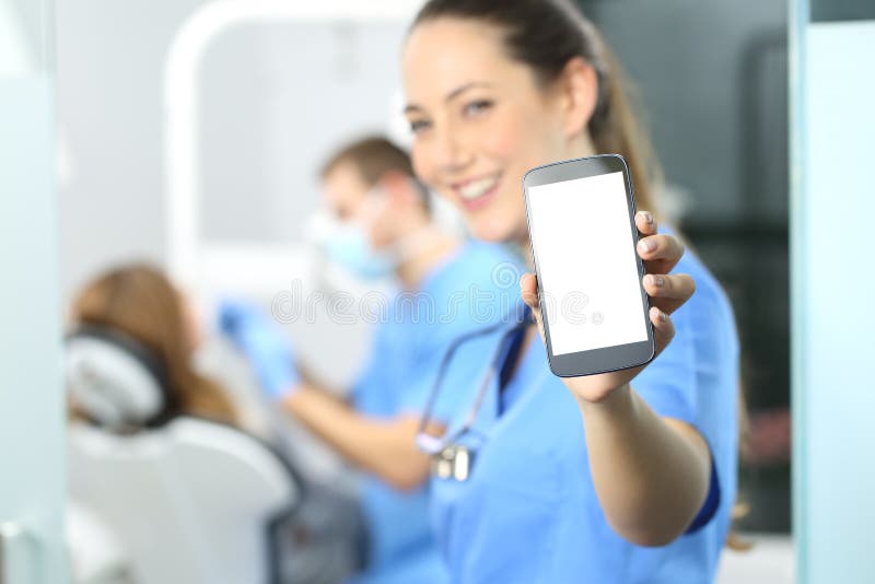 Dentista femminile che mostra lo schermo del telefono immagini stock libere da diritti Dentista femminile che mostra lo schermo del telefono immagini stock libere da diritti