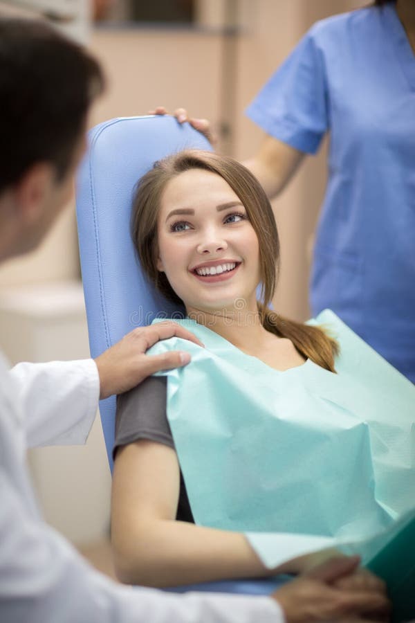 Dentista que consola o paciente foto de stock Dentista que consola o paciente foto de stock