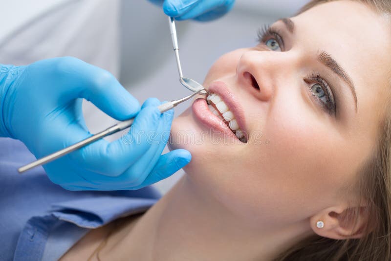 Dentista que examina os dentes de um paciente no dentista fotos de stock Dentista que examina os dentes de um paciente no dentista fotos de stock