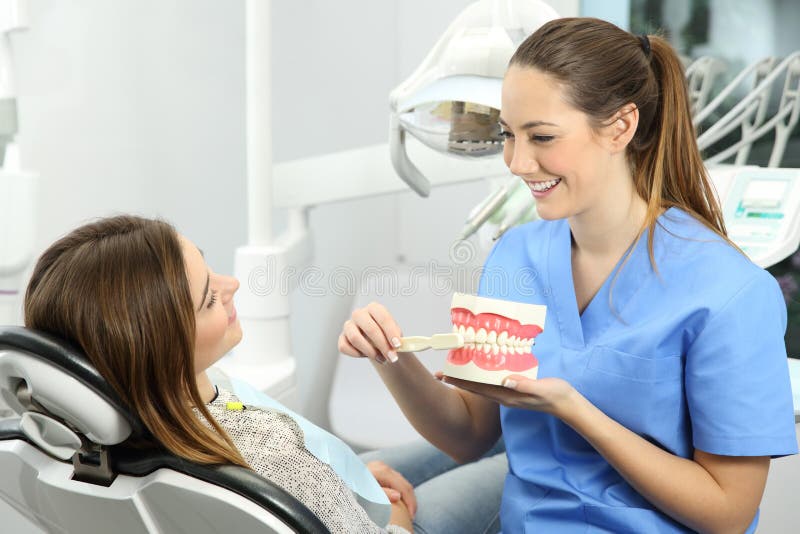 Dentista que explica como escovar os dentes imagem de stock