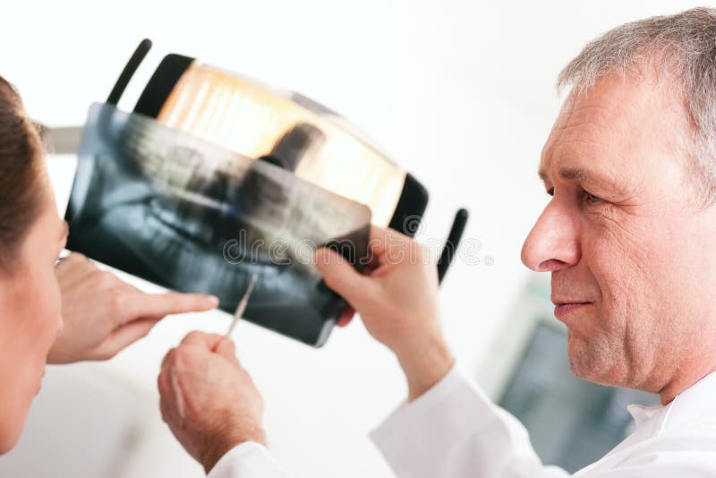 Dentista que explica o raio X ao paciente fotografia de stock