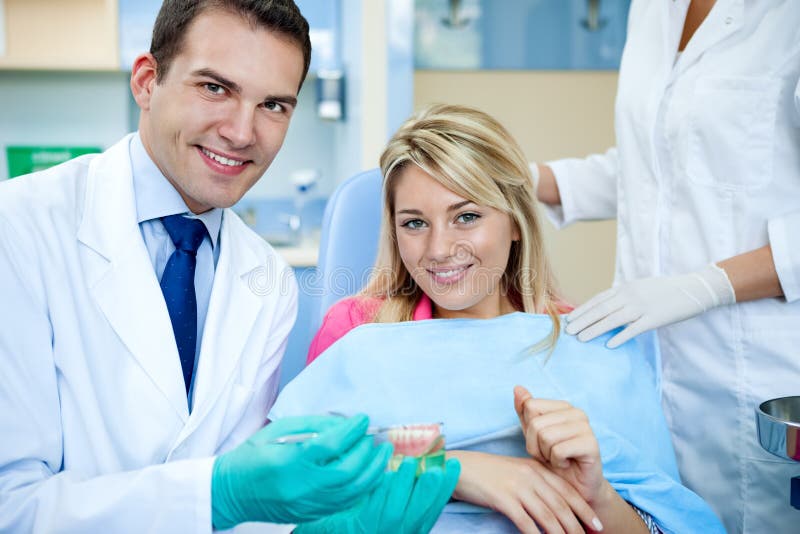 Dentista que explica um trabalho paciente fêmea da dentadura imagem de stock royalty free