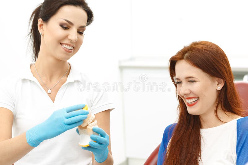Dentista que guarda os dentes falsos com paciente