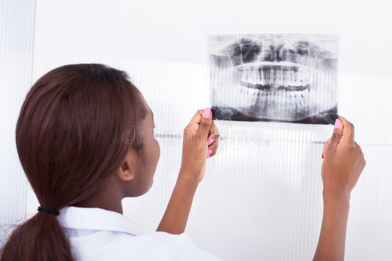 Dentista que mira la radiografía del mandíbula