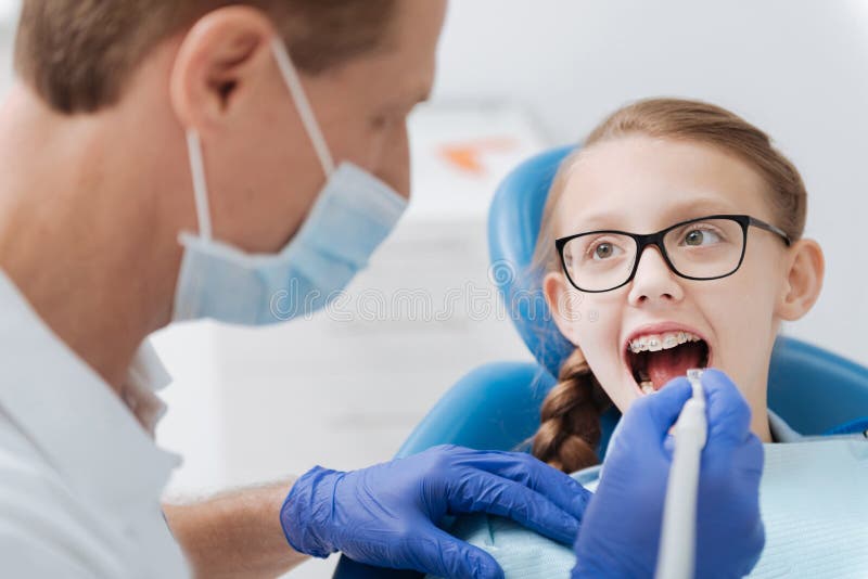 Dentista saggio formato che impiega attrezzatura moderna fotografia stock Dentista saggio formato che impiega attrezzatura moderna fotografia stock