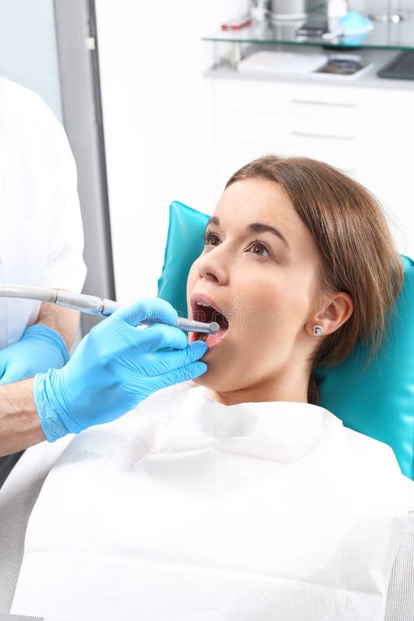 Woman at the dentist's chair during a dental procedure. Woman at the dentist's chair during a dental procedure