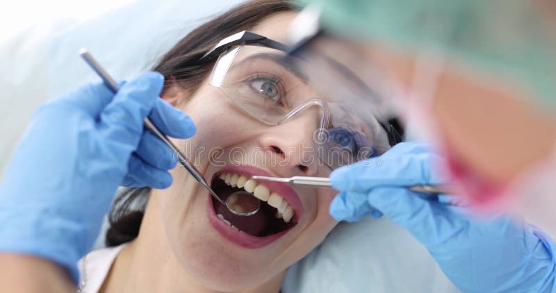 Dentiste examine les dents des femmes avec des instruments dentaires clips vidéos