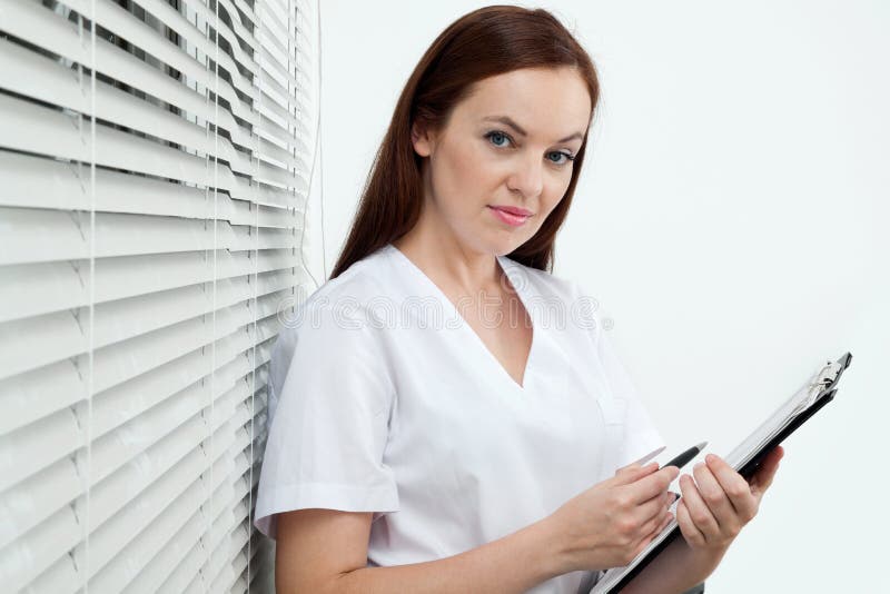 Dentiste féminin sûr Holding Clip Board et photo stock Dentiste féminin sûr Holding Clip Board et photo stock