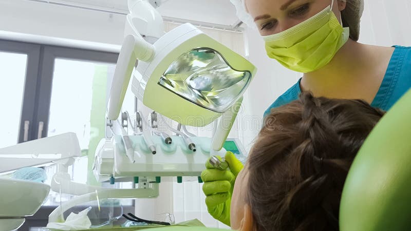 Dentiste pédiatrique disposant à forer des patients dent, méthode de dépose de carie images stock Dentiste pédiatrique disposant à forer des patients dent, méthode de dépose de carie images stock