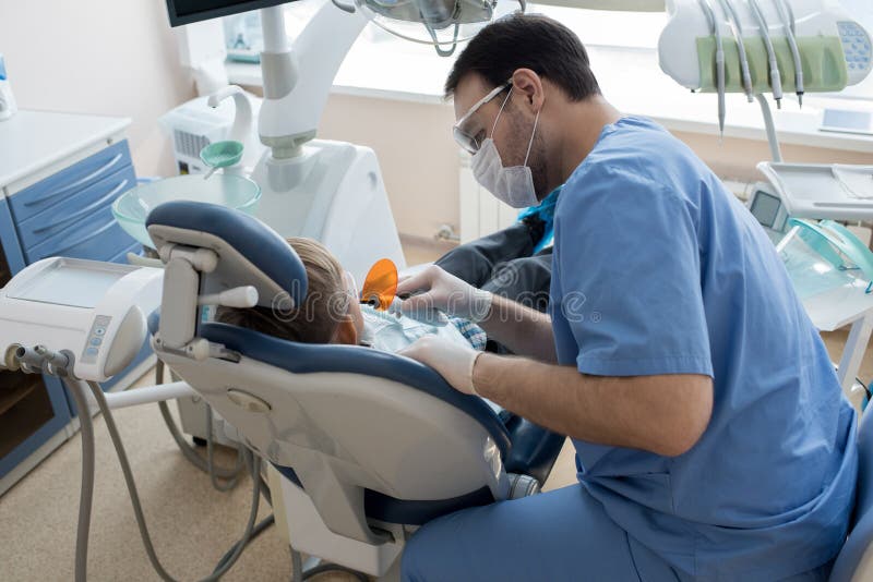 Dentiste Treating Child dans la clinique moderne photographie stock Dentiste Treating Child dans la clinique moderne photographie stock