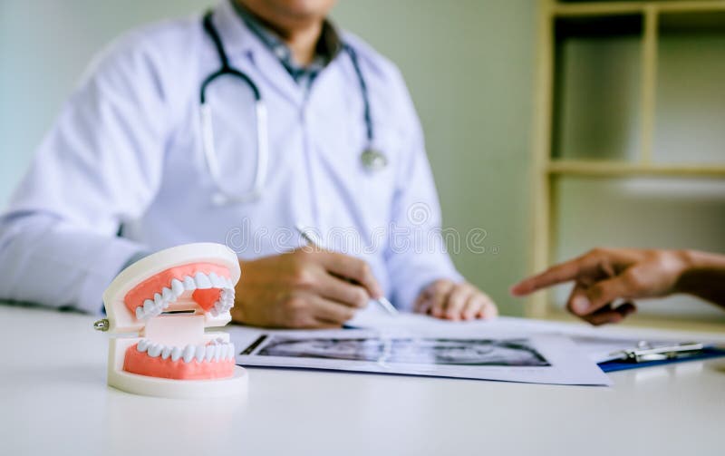Dentists are discussing dental problems at report x-ray image for patients stock photo Dentists are discussing dental problems at report x-ray image for patients stock photo