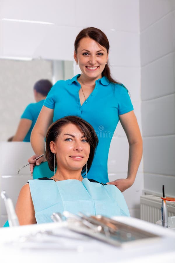 Dentysta kończy pomyślnego zębu przywrócenie, czarna z włosami lekarka w zieleni masce, daje szczęśliwy pacjenta lustro zdjęcia royalty free Dentysta kończy pomyślnego zębu przywrócenie, czarna z włosami lekarka w zieleni masce, daje szczęśliwy pacjenta lustro zdjęcia royalty free