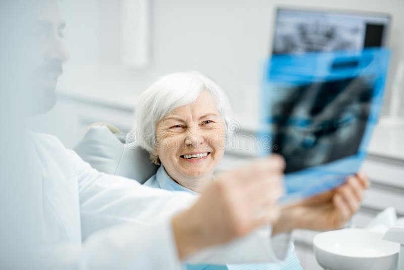 Dentysta pokazuje promieniowanie rentgenowskie stara kobieta w dentall biurze obrazy stock Dentysta pokazuje promieniowanie rentgenowskie stara kobieta w dentall biurze obrazy stock