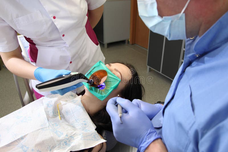 Dentysta taktuje s pacjenta ` zęby z stomatologicznymi narzędziami w stomatologicznej klinice dentyści obrazy stock Dentysta taktuje s pacjenta ` zęby z stomatologicznymi narzędziami w stomatologicznej klinice dentyści obrazy stock